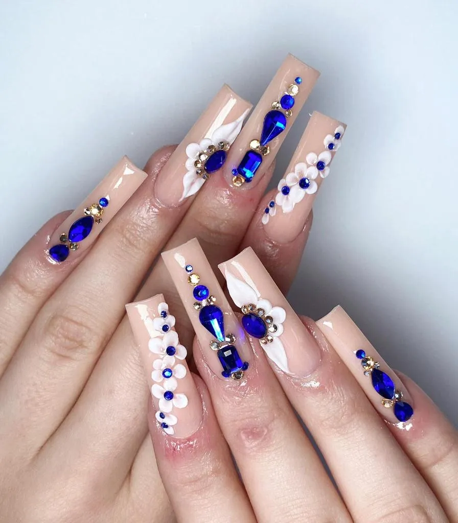 Nude nails with cobalt-blue gems and 3D white flowers, by JK Nails Chester