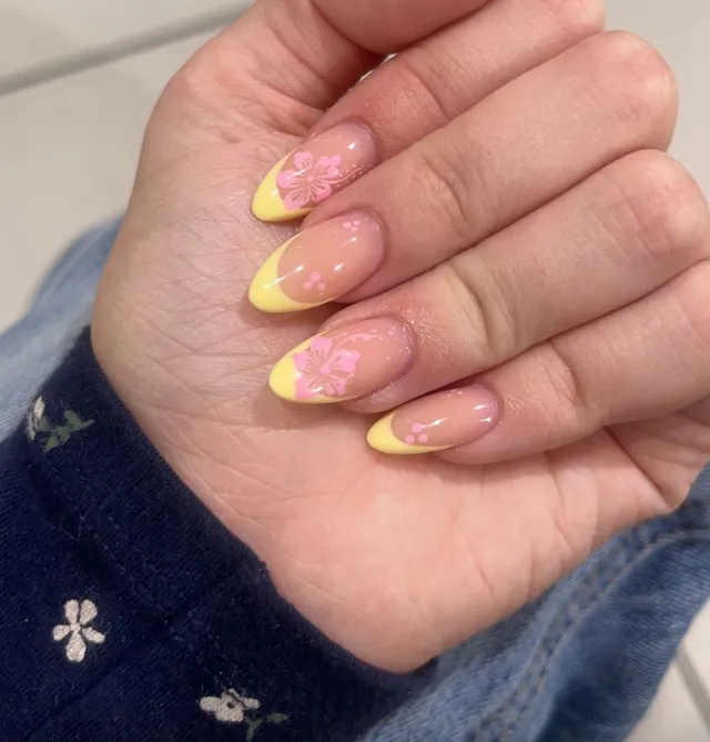 Pastel yellow French nails with pink hibiscus art